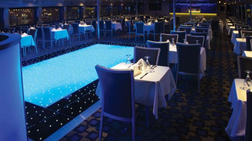 Luxury yacht dining room with illuminated dance floor and elegant seating.
